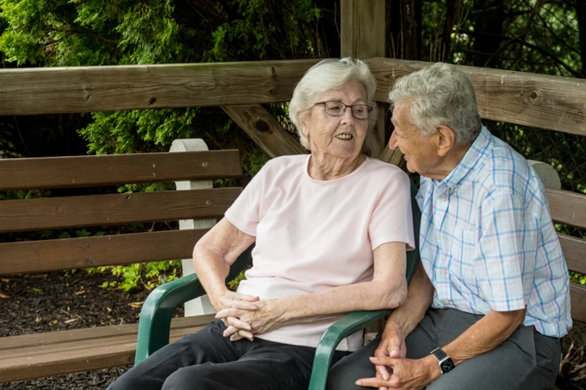 two elderly residents sitting outside