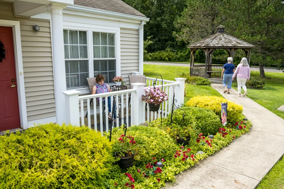 Cedar Ridge apartment exterior and people walking on sidewalk towards a gazebo