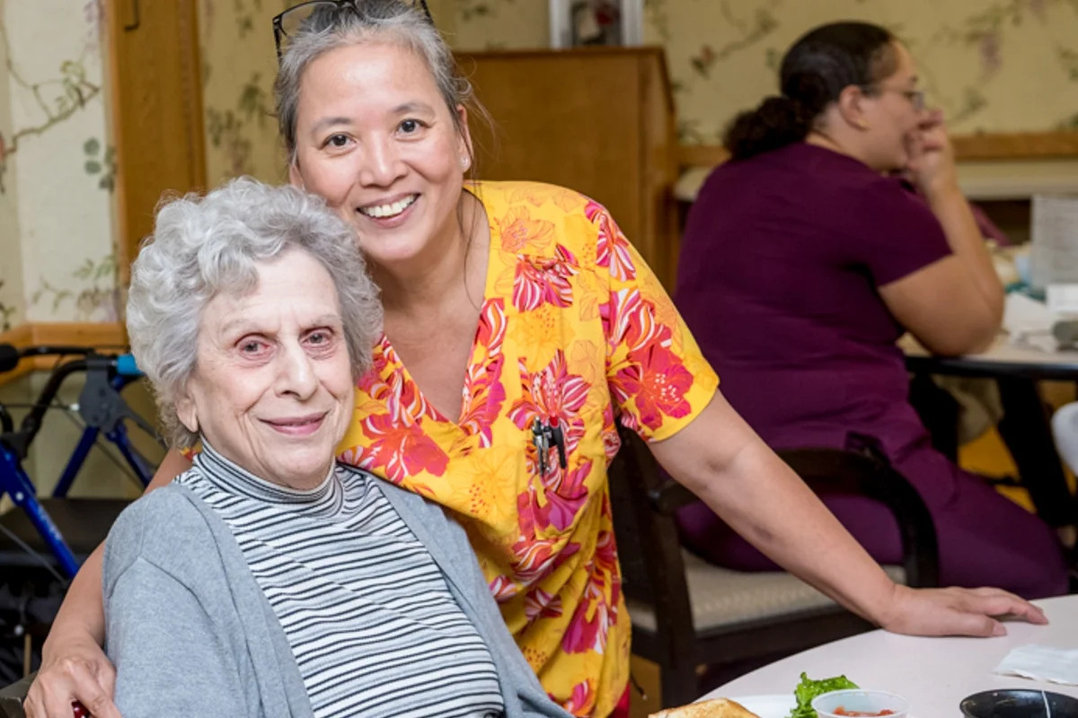 elderly resident and facility worker smiling