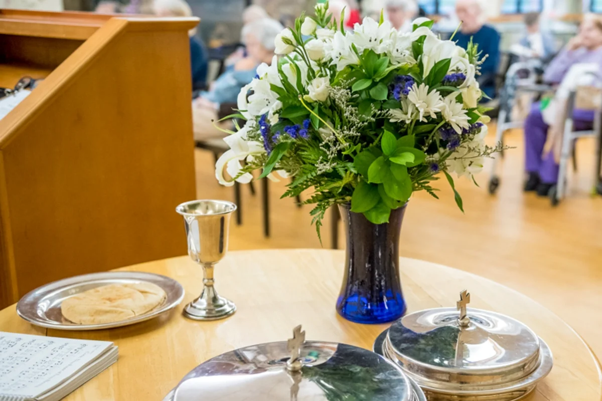 dining room table with place settings and flower vase