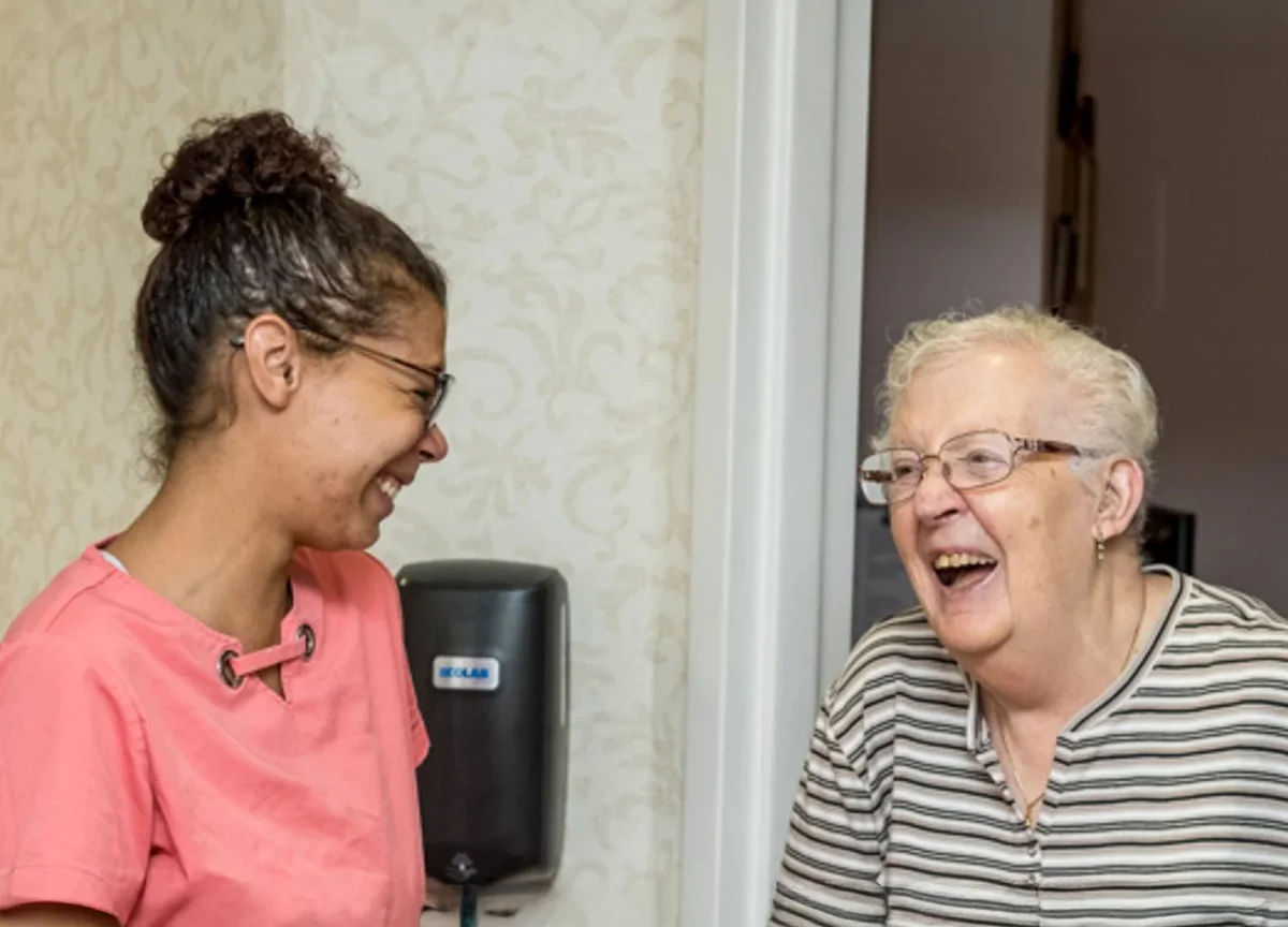 nurses aid and resident laughing together